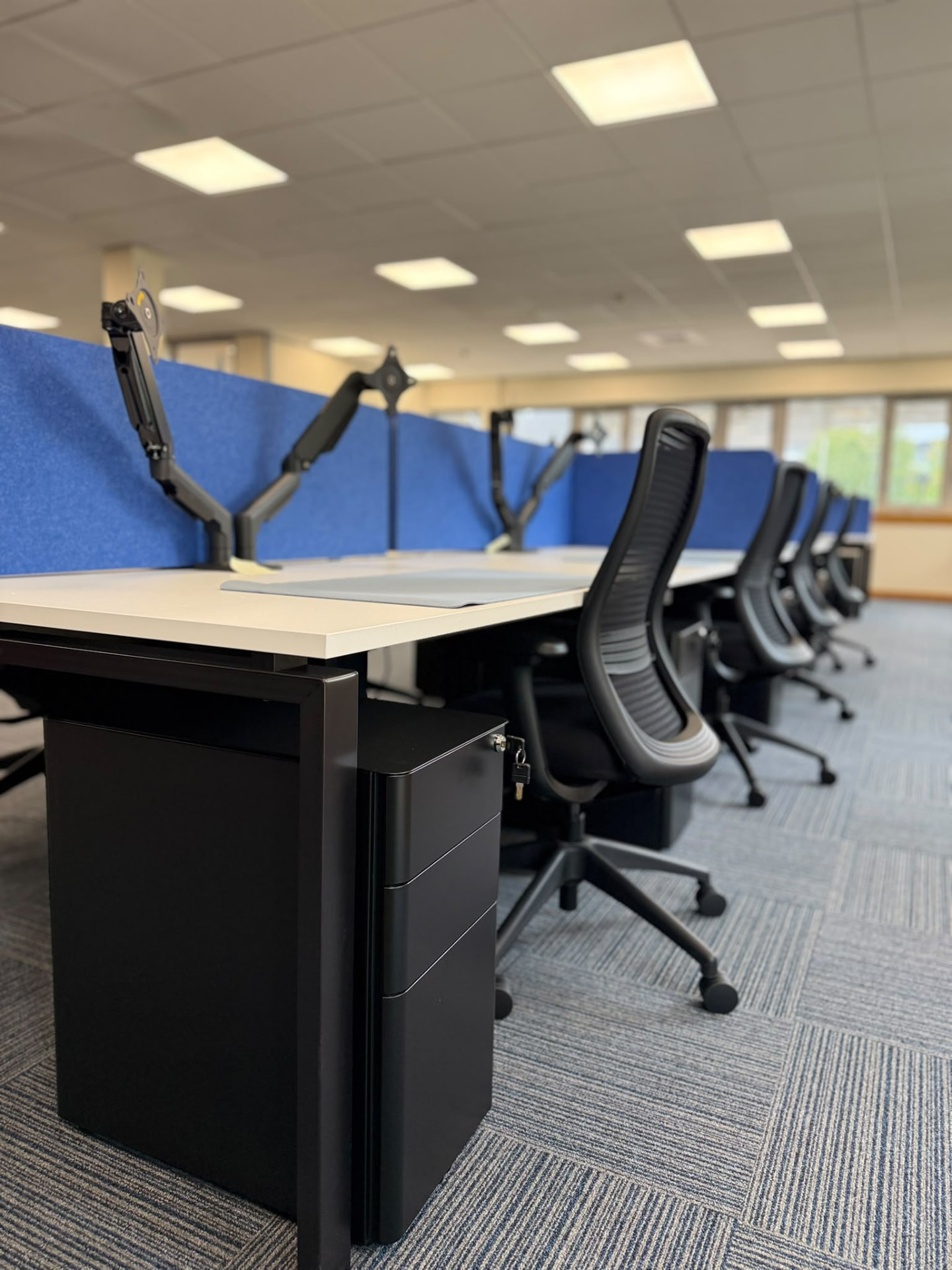 New bench desking with blue acoustic screens, monitor arms and task chairs