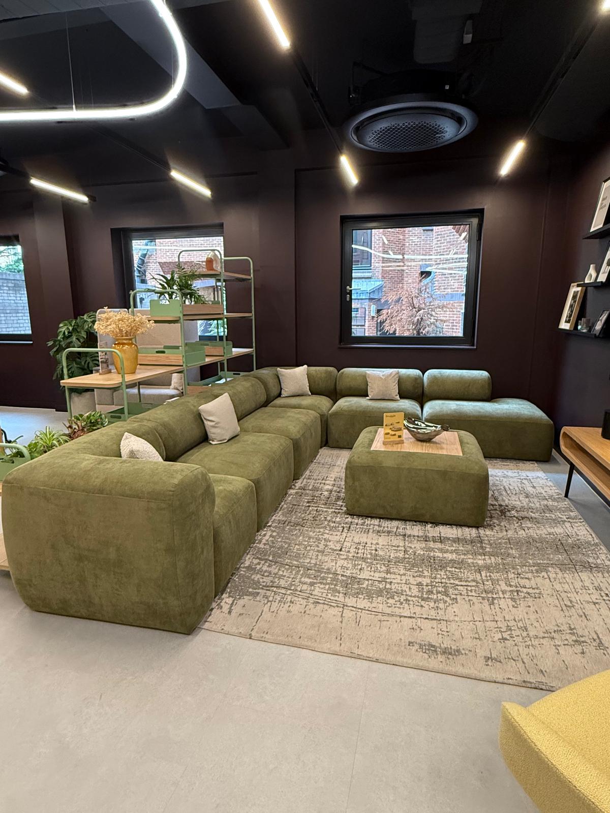 Olive modular sofa system with ottoman in a deep-toned lounge